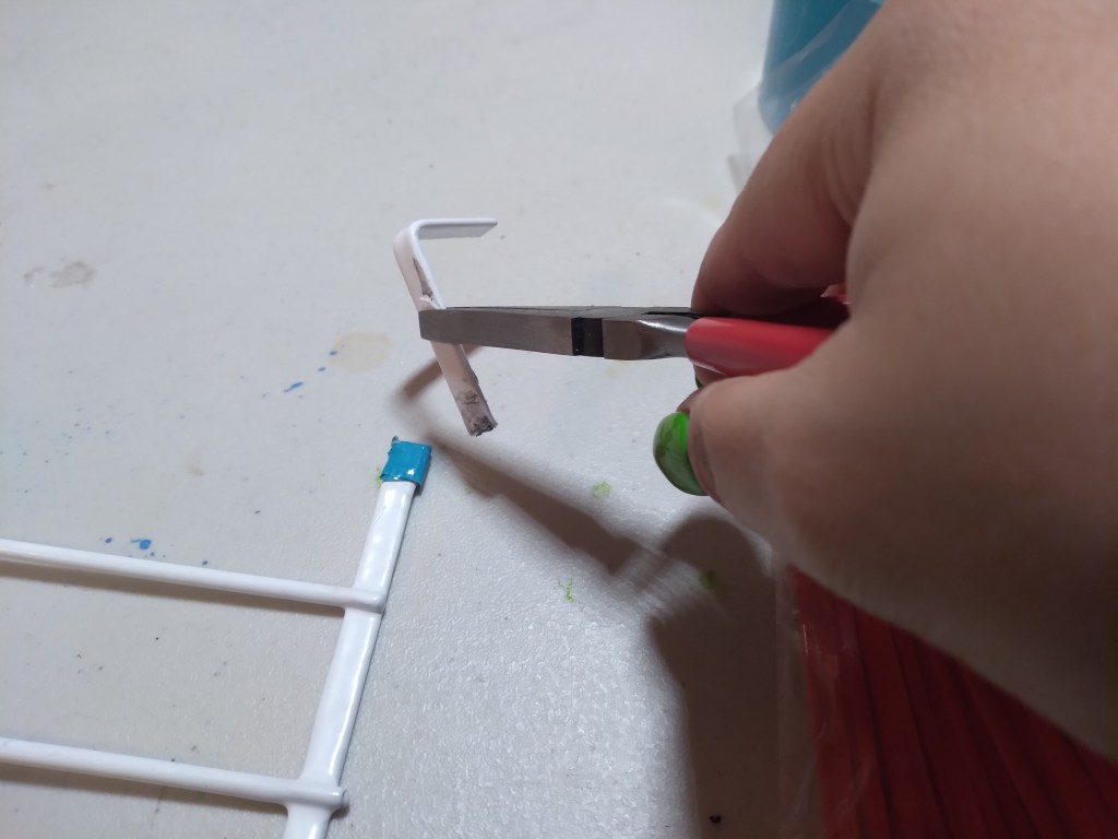 Use the pliers to bend the hooks that would normally go over the door. Bend and forth slowly and evenly until they snap off.