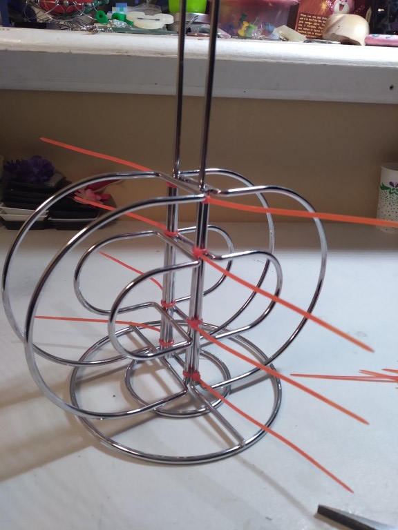 Align two of the napkin holders against the paper towel holder on opposite sides. Use zip-ties to secure them tightly to the paper towel holder.