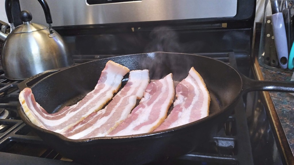 Slices of bacon heating up in an iron skillet for the Howl's Moving Castle breakfast