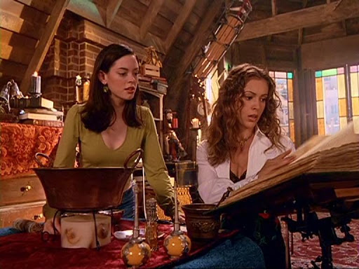 Rose McGowan and Alyssa Milano sit at a low table to cast a spell to enter Piper's mind in season 4, episode 7, "Brain Drain."