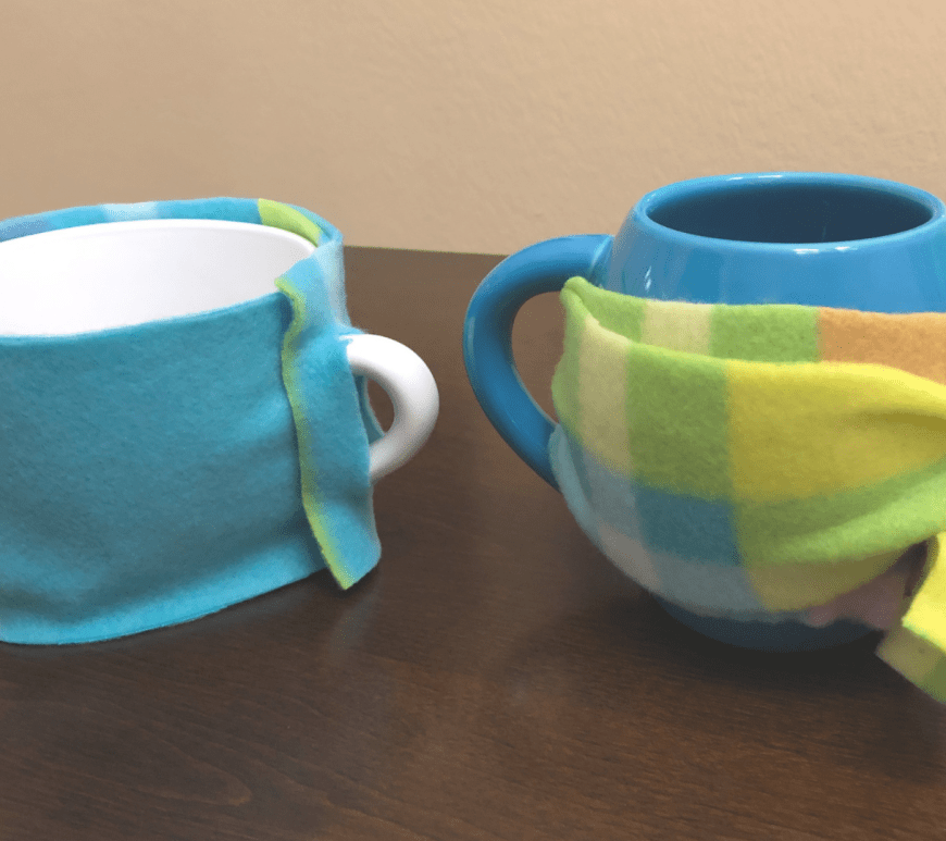 Two mugs with DIY fleece koozies wrapped around them.