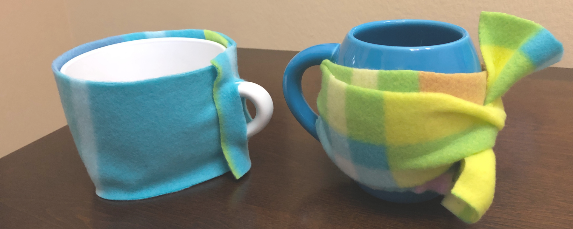 Two mugs with DIY fleece koozies wrapped around them.